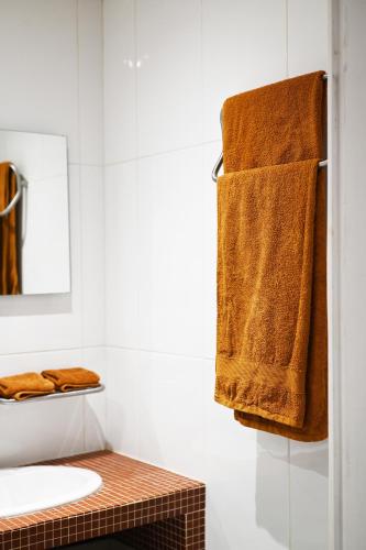 a bathroom with a sink and towels on a wall at La Dune in Salin-de-Giraud
