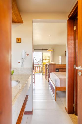 a bathroom with a bed and a sink in a room at Villa das Palmeiras Jeri in Jericoacoara