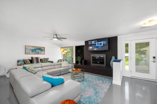 a living room with a couch and a tv at UF SUNSHINE HOUSE - Patio & BBQ - Chef Kitchen - EV Car Station - Upscale Neighborhood! in Gainesville