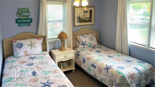 una camera con 2 letti singoli e un comodino di Dottys Cottage a Cape May