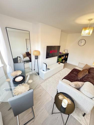 a living room with a couch and a tv at Twos Company in Brookmans Park