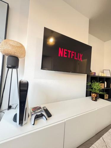 a tv on a wall with a netflix sign at Twos Company in Brookmans Park