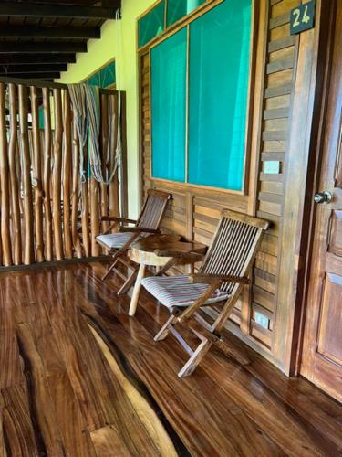 two chairs and a table on the porch of a cabin at La Ensenada Lodge in Abangaritos