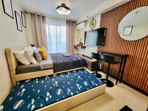 a bedroom with a bed and a desk and a mirror at Welcome to Cozy Staycation in Suba
