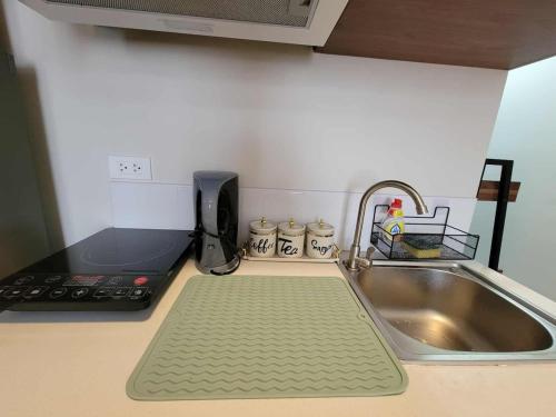 a kitchen counter with a sink and a cutting board at Welcome to Cozy Staycation in Suba