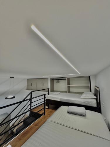 a room with two beds and a stair case at Nest Apartments in Tirana