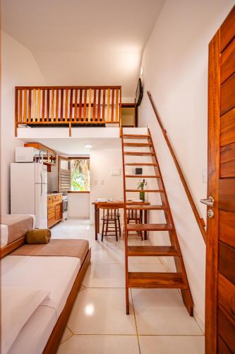 a living room with a spiral staircase and a kitchen at Villa das Palmeiras Jeri in Jericoacoara