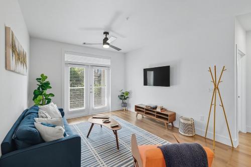 a living room with a blue couch and a tv at 336 Chic 2B2B Near Stockyards, Resort Style Pool & Gym, Golf Simulator, 7M to Dickies Stadium, 15M to AT&T stadium in Fort Worth