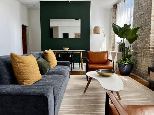 a living room with a blue couch and a table at Stylish Industrial Loft in Warehouse District in New Orleans