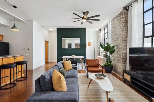 a living room with a blue couch and a table at Stylish Industrial Loft in Warehouse District in New Orleans