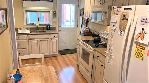 a kitchen with a white refrigerator and a table at Flip Flop Beach in Cape May Point