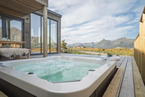 a bath tub with a view of the mountains at Stunning Lofoten Lodge with views and jacuzzi in Lyngværet