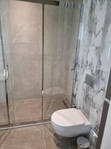 a bathroom with a toilet and a glass shower at Modern 1-Bedroom Apartment at Sea Breeze Park Residences 2, Just Steps from the Beach, with Pool, Gym, Restaurants and Free Parking in Nardaran