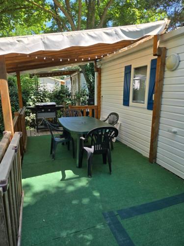 a patio with a table and chairs and a grill at Iscles 231- MH Au calme près du lac in La Roque-dʼAnthéron