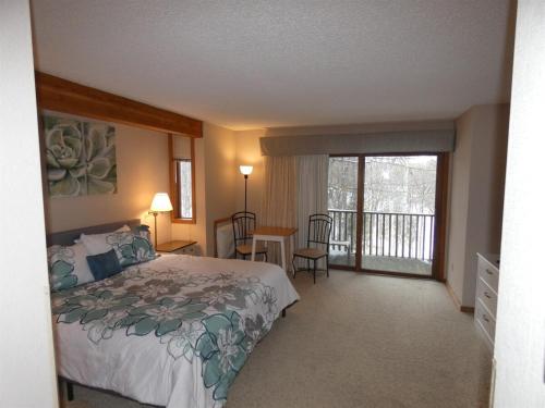 una camera da letto con un letto e un balcone di Timber Ridge Retreat a Bellaire