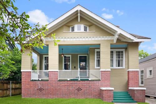 Una pequeña casa con un porche y un ladrillo. en Spacious and Elegant Family Home in Mid-City, en Nueva Orleans