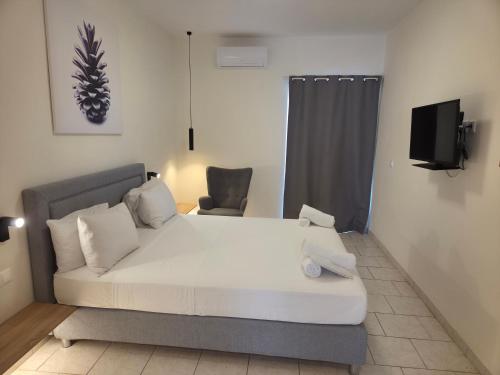 a bed in a room with a couch and a tv at Koukounari Agistri in Skala