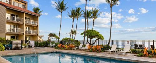 a pool at a resort with chairs and palm trees at Worldmark Kapaa Shore in Kapaa