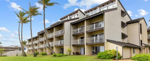 an apartment building with palm trees in front of it at Worldmark Kapaa Shore in Kapaa