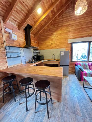 a kitchen and living room with a counter and stools at Cabaña Nativo in Minetué