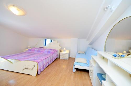 een witte slaapkamer met een bed en een spiegel bij Apartments Biserka in Štanga