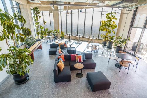 a large room with a couch and tables and plants at Stylish apartments by VIATO HOMES in Mexico City