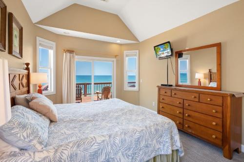a bedroom with a bed and a dresser with a mirror at 8045 - Mirlo Hi in Rodanthe