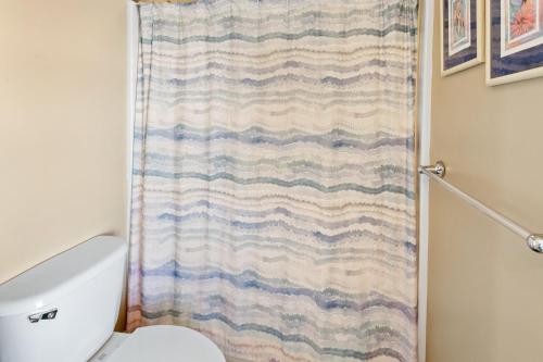 a bathroom with a shower curtain and a toilet at 8045 - Mirlo Hi in Rodanthe
