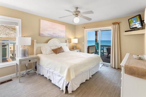 a bedroom with a bed with a desk and a window at 8045 - Mirlo Hi in Rodanthe