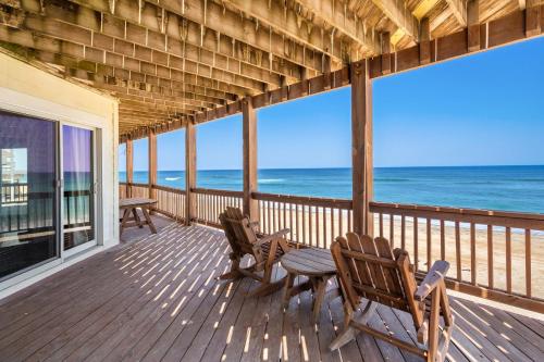 a porch with chairs and a table and the ocean at 8045 - Mirlo Hi in Rodanthe