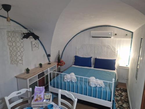 a bedroom with a blue bed with an arched ceiling at Casetta Relax in Gaeta