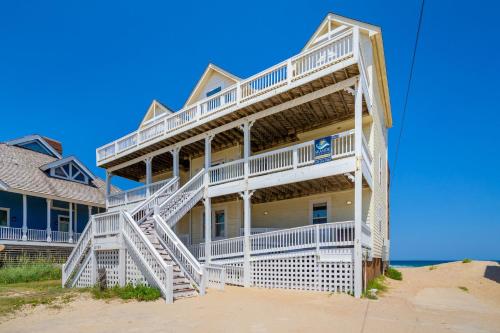 a large house with white stairs on the beach at 8045 - Mirlo Hi in Rodanthe
