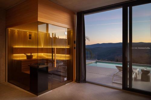 un bagno in vetro con vista sulle montagne di Villa Immortella a Rabac