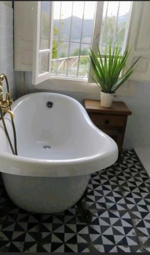 a white bath tub in a bathroom with a window at El nido del dragón in Carratraca