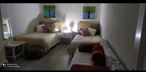 Un dormitorio con dos camas y un sofá. en El nido del dragón, en Carratraca