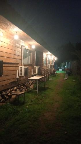a picnic table in front of a cabin at night at Refúgiate con Nosotros Limache in Lo Narváez