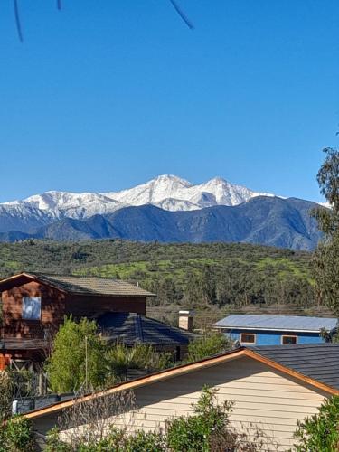 a view of snow capped mountains from a house at Refúgiate con Nosotros Limache in Lo Narváez