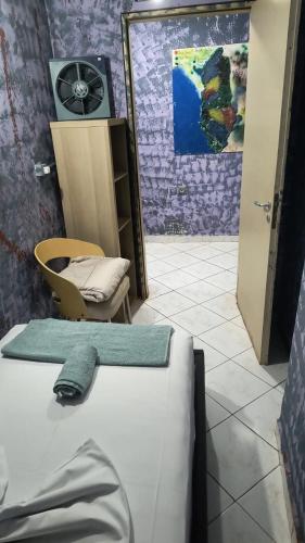 a room with a bed and a chair and a mirror at War Bunker Hostel in Sarandë