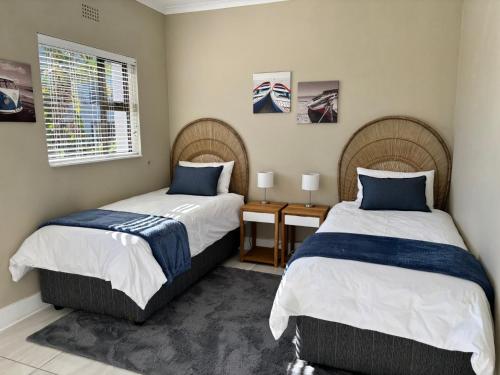 プレッテンバーグ・ベイにあるThe Nest at Castletonのベッド2台と窓のある寝室