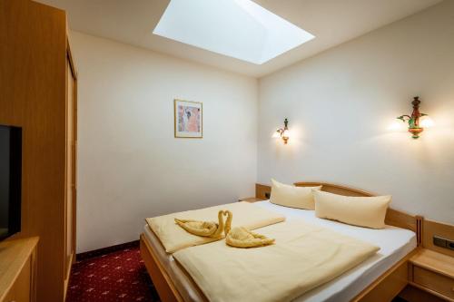 a bedroom with a bed with two towels on it at Hotel ALPINJUWEL 3-Sterne Superior in Gerlos