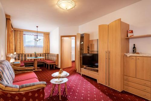 a living room with a couch and a tv at Hotel ALPINJUWEL 3-Sterne Superior in Gerlos