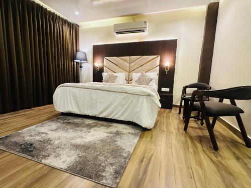 a bedroom with a bed and a desk and a chair at Aruna Farm House in Kakarmatha