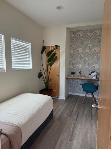 a bedroom with a bed and a desk and a plant at Ocean View condo in the heart of Manhattan Beach in Manhattan Beach