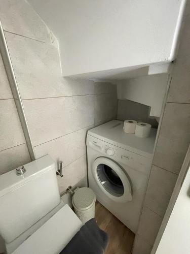 a small bathroom with a washing machine in it at Melodia Lefkada Maisonette 3 in Nikiana
