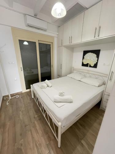 a bedroom with a large white bed with towels on it at Melodia Lefkada Maisonette 3 in Nikiana