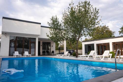 a swimming pool in front of a house at Mukhrani Villa Private Pool Near Tbilisi in Mukhrani