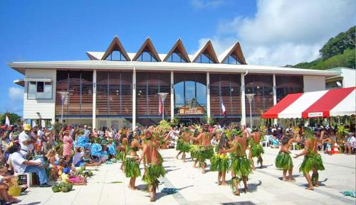 a crowd of people watching a performance in front of a building at VILLA DE LA BAIE RAIATEA - Bord de mer in Uturoa
