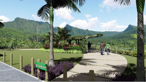 a park with a palm tree and people walking on a sidewalk at VILLA DE LA BAIE RAIATEA - Bord de mer in Uturoa