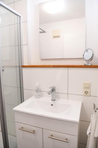 a bathroom with a white sink and a mirror at Panorama Apartment mit Balkon in Bad Urach