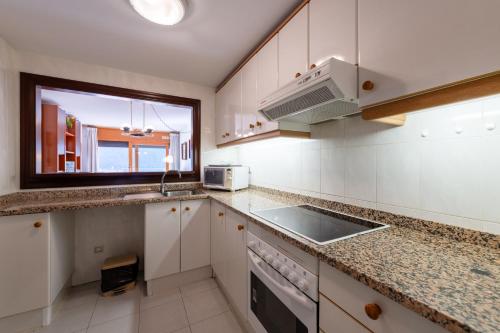 a kitchen with white cabinets and a sink and a window at Barthe Holidays I Apartamento céntrico en Escaldes 4PAX I Ideal parejas, Terraza y confort I Manhattan in Escaldes-Engordany